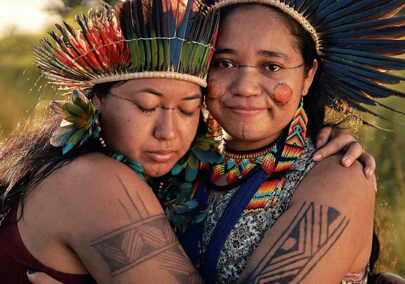 Hamangai Marcos Melo Pataxó and her sister Itocovouty Galache Melo embrace for a portrait. Their experiences of violence have strengthened both women in their struggle.